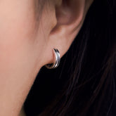Fine jewellery, silver jewellery, hypoallergenic, tarnish-free, close-up right view of a  silver glazed black hoop earrings worn on a person's ear
